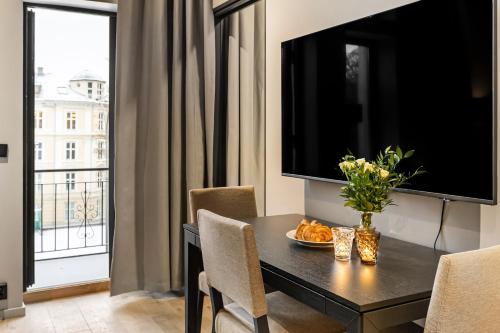 a dining room with a table and a large window at The APARTMENTS Company- Frogner in Oslo