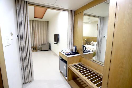 een hotelkamer met een spiegel en een kamer bij HOTEL BLUE PEARL in Bhopal