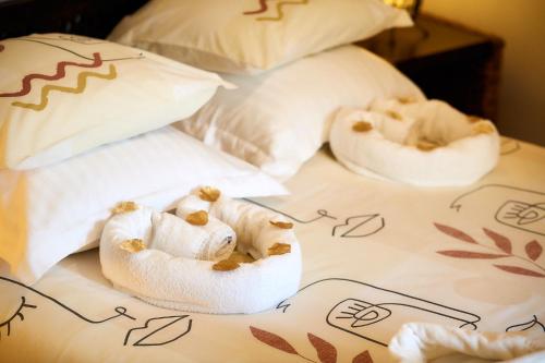 dos toallas enrolladas encima de una cama en L'Aigrette, en Le Hanouard