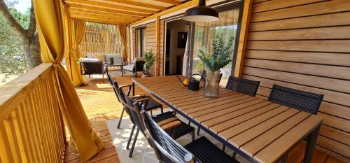 una mesa de madera y sillas en un porche en Mobile home Luka, en Kruševo