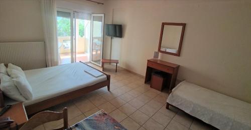 a bedroom with a bed and a mirror and a table at HotelApart Filoxenia in Alexandroupoli