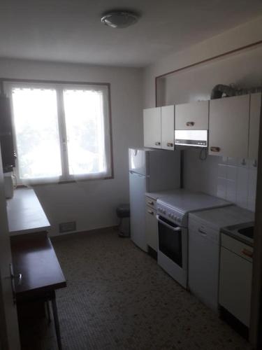 a small kitchen with white appliances and a window at Appartement T3 68 M2 Saint Avertin. in Saint-Avertin