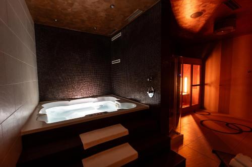 a bathroom with a white tub in a black wall at Roset Hotel & Residence in Bratislava