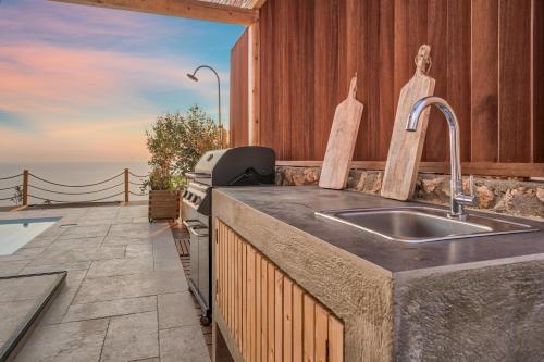 a kitchen with a sink and a view of the ocean at Eunoia Porto Katsiki in Áyios Nikólaos Nirás