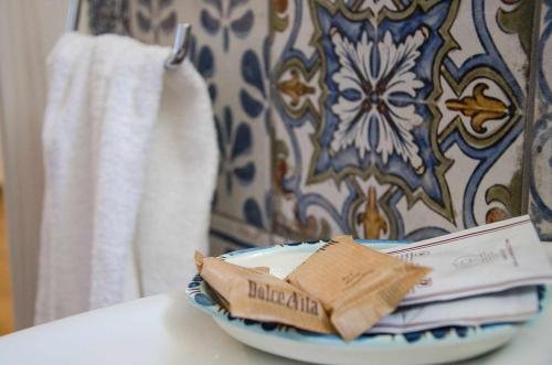 una ciotola su un tavolo con un libro e asciugamani di Appartamenti La Baia del Raìs a Falcone