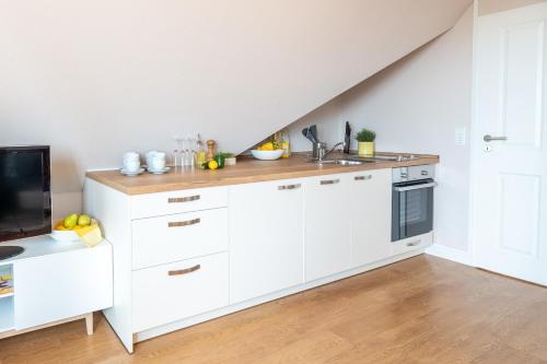 a kitchen with white cabinets and a sink at CNS-a-4-18 - 2-Raum Appartement in Cappel-Neufeld