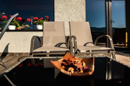 two chairs sitting on a balcony with a fire pit at Bucovina Lodge Pension in Vama