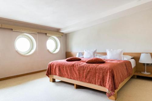 una camera da letto con un letto grande con due finestre di Roset Hotel & Residence a Bratislava