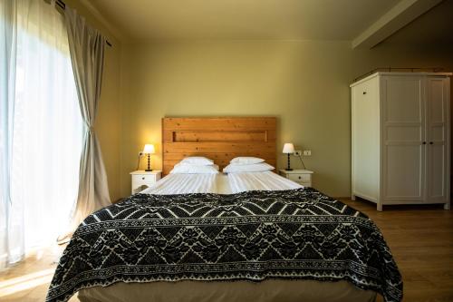 a bedroom with a large bed with a black and white blanket at Bucovina Lodge Pension in Vama