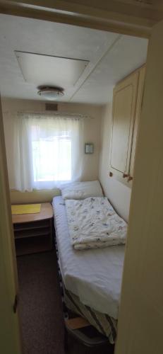 a small bedroom with two beds and a window at Relaxing home in Svarstad