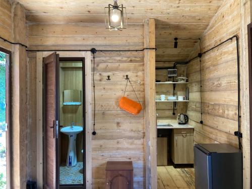 La salle de bains est pourvue d'un mur en bois et d'une porte. dans l'établissement MESTIA COTTAGE TiME, à Mestia