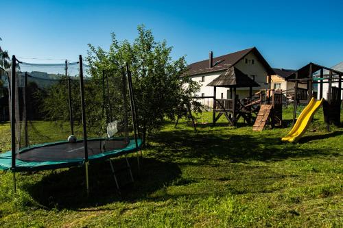 a park with a playground with a slide at Bucovina Lodge Pension in Vama