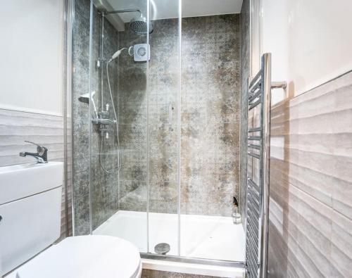 y baño con ducha de cristal y aseo. en 5 Bed Farmhouse Suitable for Contractors Private Parking, en Potter Street
