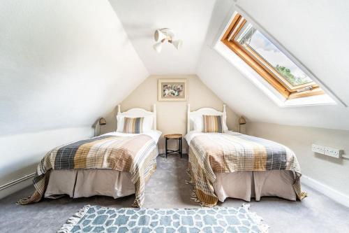 two beds in a attic room with a skylight at 5 Bed Farmhouse Suitable for Contractors Private Parking in Potter Street