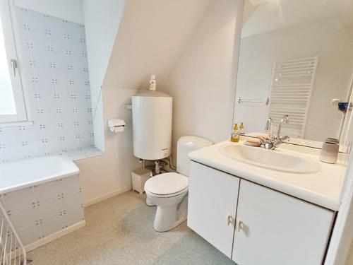 une salle de bain blanche avec des toilettes et un lavabo dans l'établissement Chez Charlotte, T3 duplex, vue montagne, parking gratuit, ascenseur, 4 personnes, à Luchon