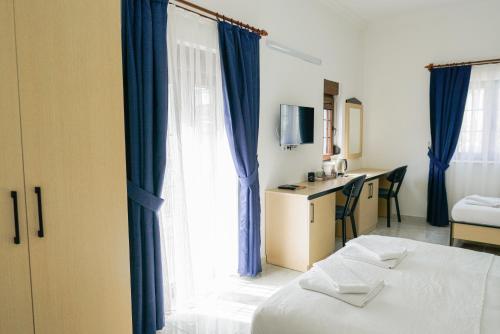 a room with a bed and a window with blue curtains at Villa Hania Boutique Hotel - Adults only in Side