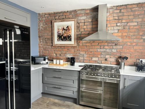 a kitchen with a brick wall and a stove at River View in Keynsham