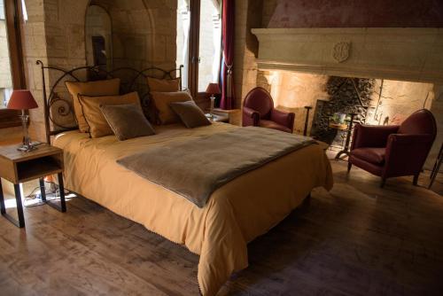um quarto com uma cama grande e 2 cadeiras em Hôtel particulier Fénelon (XIIIe) em Sarlat-la-Canéda