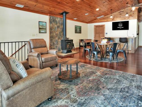 - un salon avec un canapé, une table et une cheminée dans l'établissement Lakefront Lodge with King Beds and Game Lounge, à Worthville