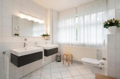 y baño con 2 lavabos, aseo y espejo. en Villa am Hang Wohnung 11 en Grömitz