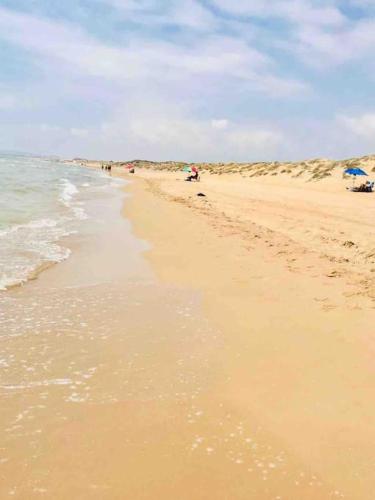 a beach with people walking on the sand and the ocean at Wishome - Villa Bonita en Alicante in Elche