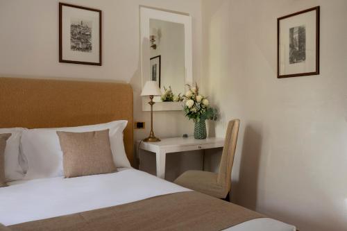 a bedroom with a bed and a table with a chair at Castello di Leonina Relais - Adults Only in Siena