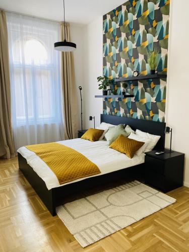 - une chambre avec un grand lit et un mur coloré dans l'établissement Birdie6, à Budapest