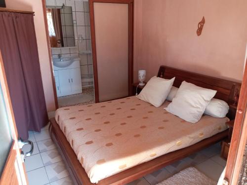 um quarto com uma cama num pequeno quarto em Hôtel restaurant le MIAMIAM GLOUGLOU em Ambositra