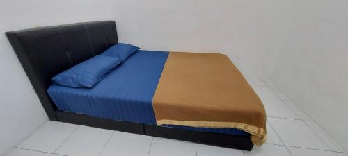 Una cama con una manta azul y marrón. en HDA Homestay Alor Setar Untuk Muslim Sahaja, en Alor Setar