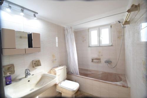 a bathroom with a tub and a sink and a toilet at Villa Eirini Agia Varvara Lesvos in Plomari