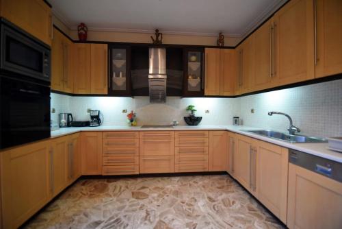 a kitchen with wooden cabinets and a sink at Villa Eirini Agia Varvara Lesvos in Plomarion