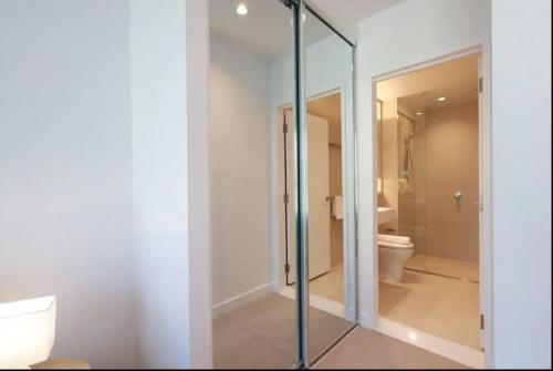 a glass shower in a bathroom with a toilet at Modern 2BR nr Yara river, city view, Free parking in Melbourne