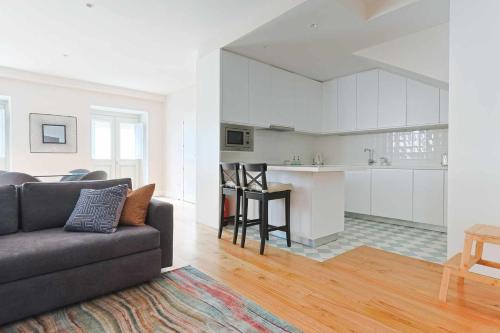 Una sala de estar con un sofá y una cocina. en Downtown Charming Apartments Apartamento Poldras, en Chaves