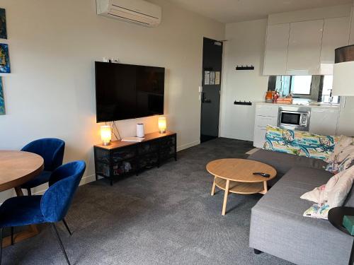 a living room with a couch and a flat screen tv at Lovely 2-bedroom apartment, breathtaking view! in Frankston