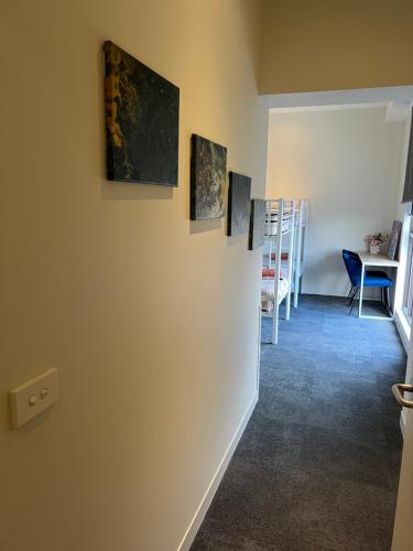 a hallway with three paintings on the wall at Lovely 2-bedroom apartment, breathtaking view! in Frankston