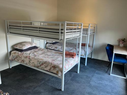 a bedroom with two bunk beds and a desk at Lovely 2-bedroom apartment, breathtaking view! in Frankston