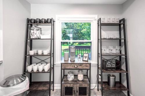 Zimmer mit Regalen mit Vasen und einem Fenster in der Unterkunft Pet Friendly Cozy 3BRM fully Fenced yard in Durham