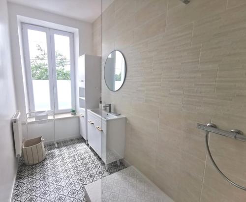 La salle de bains blanche est pourvue d'un lavabo et d'un miroir. dans l'établissement Nouveau - Au bout du quai, à Nantes