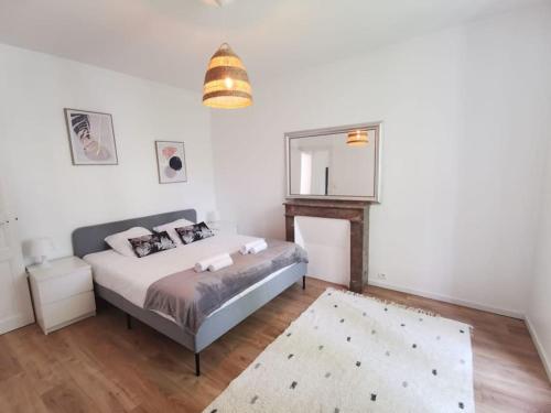 1 dormitorio con cama y espejo en Nouveau - Au bout du quai en Nantes