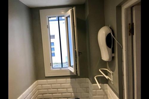 a bathroom with a window and a sink and a toilet at Charmant studio plein centre in Fontainebleau