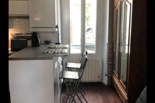 a kitchen with two chairs and a counter top at Charmant studio plein centre in Fontainebleau