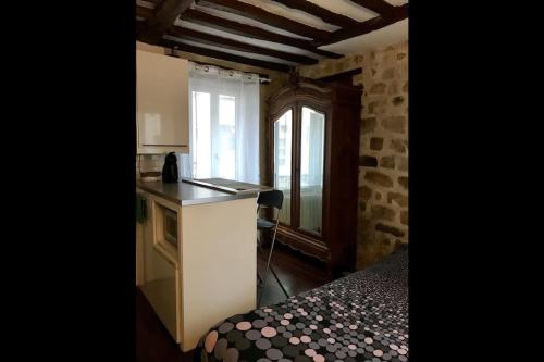 a small kitchen with a counter and a window at Charmant studio plein centre in Fontainebleau