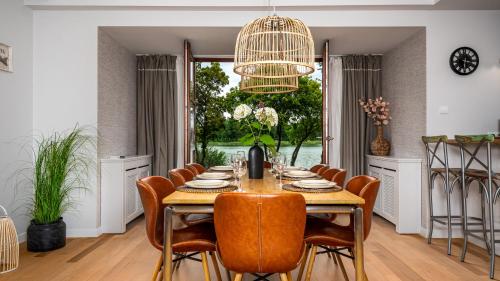 a dining room with a table and chairs and a chandelier at Domy nad Jeziorem Sun & Snow Osada Zamkowa in Pasym