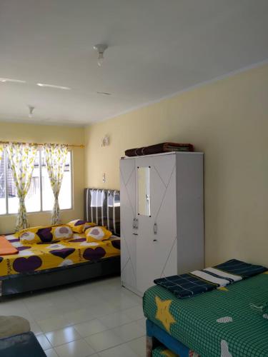 a bedroom with two beds and a cabinet in it at Villa Highland No 7 M Berastagi View in Berastagi