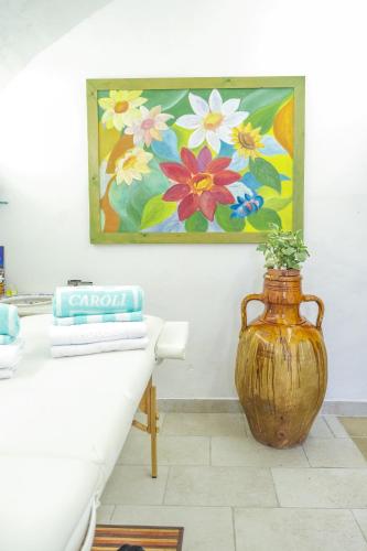 a vase sitting on a table next to a painting at Hotel Terminal - Caroli Hotels in Leuca