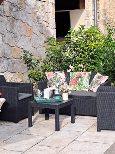 a patio with a bench and a table with flowers at Gite Mireille in Carros