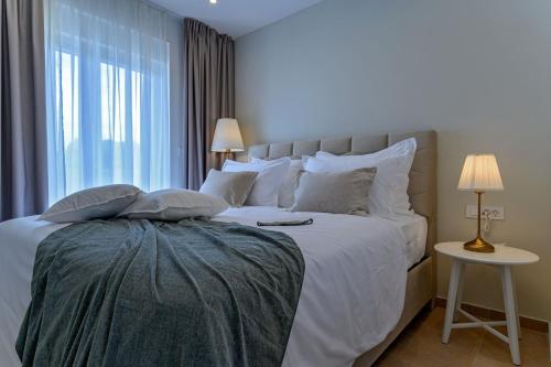 a bedroom with a large white bed with a window at Luxury Villa Del Sogno with pool, jacuzzi, parking in Trogir