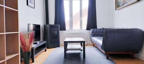 uma sala de estar com um sofá e uma mesa em LE PERCHOIR em Corbeil-Essonnes