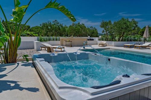 a pool with a hot tub in a backyard at Luxury Villa Del Sogno with pool, jacuzzi, parking in Trogir
