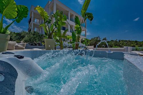 a pool with a water fountain in front of a building at Luxury Villa Del Sogno with pool, jacuzzi, parking in Trogir